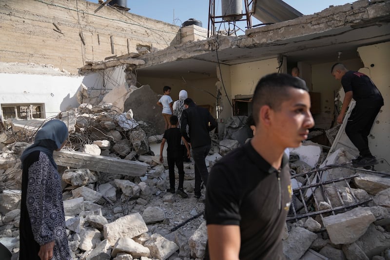 Palestinians inspect a damaged house that was raided by the Israeli army in the West Bank town of Abu Dis, Sunday, Nov. 5, 2023.