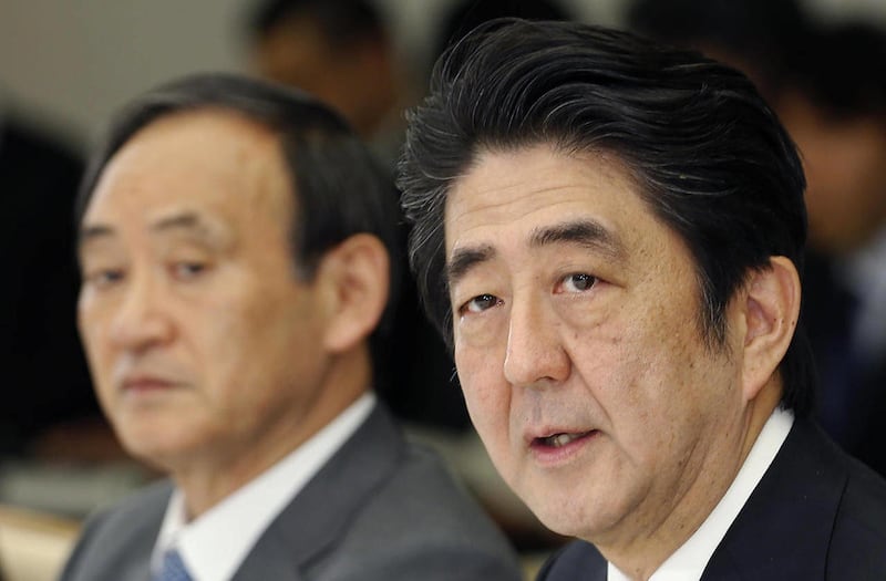 Japanese Prime Minister Shinzo Abe, right, speaks at a meeting with a panel of experts at his official residence in Tokyo, Wednesday, Feb. 25, 2015. Abe is starting a three-day visit to California with plans to check out some of the region's tech innovati