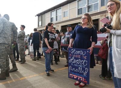 Erin Mcanlay, 35, of Layton, holds a sign while waiting to welcome home her husband from a seven-month deployment to the Middle East with the 729th Air Control Squadron at Hill Air Force Base on Monday, April 29, 2019. The 128 airmen that deployed contrib