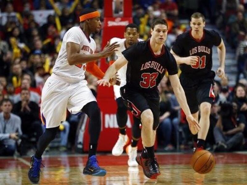 Newly signed Chicago Bulls guard Jimmer Fredette dribbles past New York Knicks guard Toure' Murry during the second half of an NBA basketball game on Sunday, March 2, 2014, in Chicago. The Bulls won 109-90. (AP Photo/Jeff Haynes)