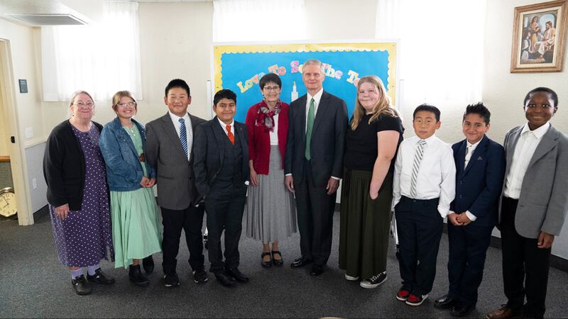 Elder David A. Bednar of the Quorum of the Twelve Apostles and his wife, Sister Susan Bednar, stand with a Primary class in Salt Lake City during the filming of the upcoming Friend to Friend event streaming on Saturday, Feb. 15, 2025.