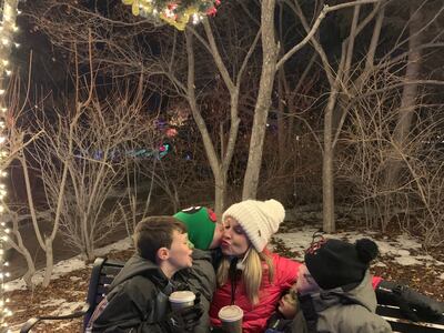Carmen Herbert's boys give her a kiss under the mistletoe at Thanksgiving Point's Luminaria