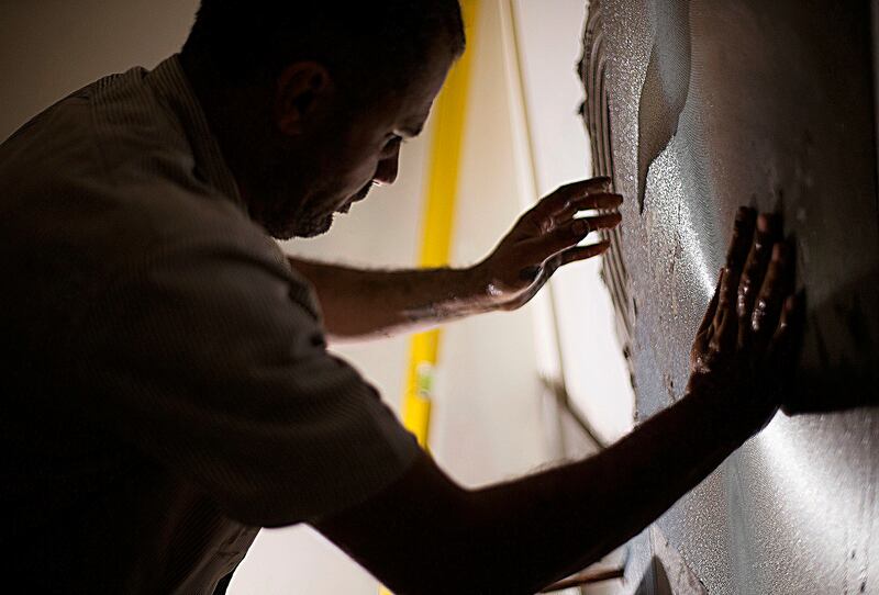 Malek Hamad tiles the interior of a nail salon in Salt Lake City on Sept. 6., but has taken a new job with a window installation company that offers him more hours. That overtime is helpful for meeting expenses, such as the nearly $1,000 a month for rent.