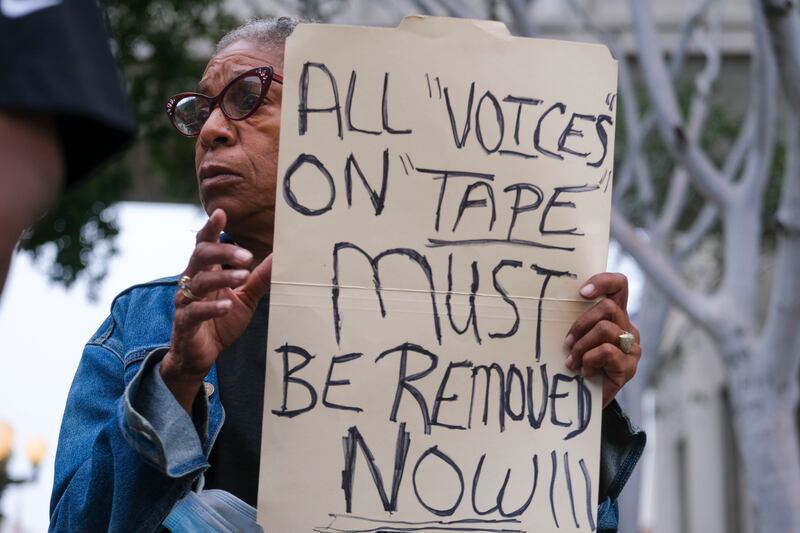 Veronica Sance holds a sign in a news conference before the Los Angeles City Council meeting outside city hall.