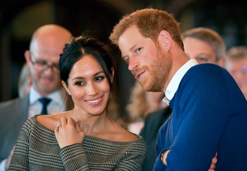 Prince Harry talks to Meghan Markle as they watch a dance performance by Jukebox Collective in the banqueting hall during a visit to Cardiff Castle, Wales.