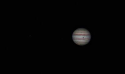 Jupiter with the shadow of its moon Callisto, the dark blotch; the great red spot, which is the pale salmon object to the shadow's lower right; and a scar of a comet impact, barely showing on the planet's lower left limb. Here, Jupiter is a place, not a p