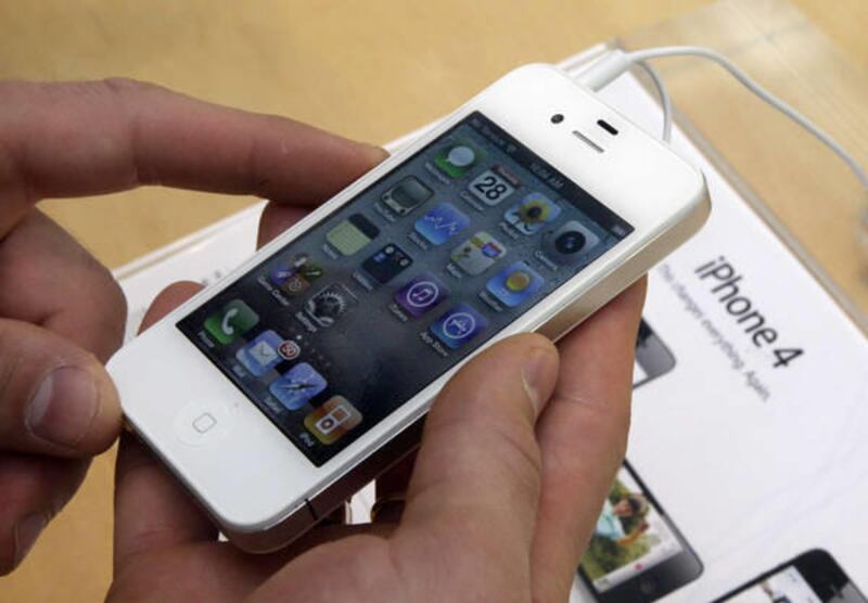 In this April 28, 2011 photo, a customer holds a white iPhone at the Apple store on New York's Upper West Side.
