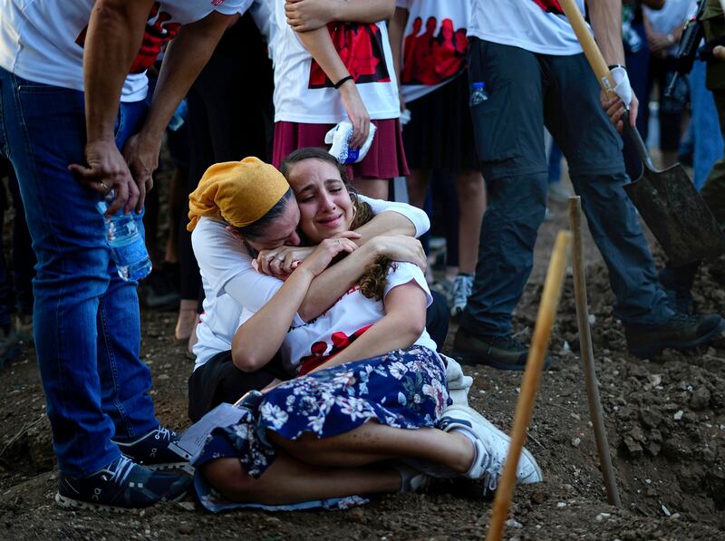 Mourners gather at the graves of British Israelis Lianne Sharabi and her two daughters, Noiya and Yahel.