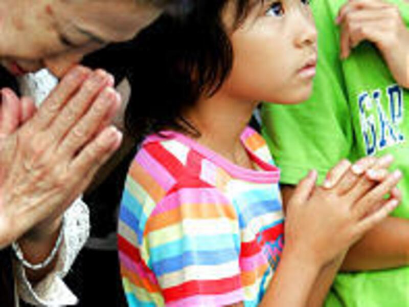 A girl prays in front of the Statue of Peace at Nagasaki's Peace Park Tuesday. The bomb killed 80,000, hastening Japan's surrender.