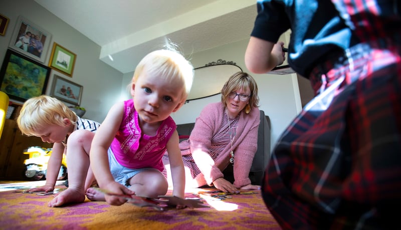 Frances Johnson plays with her children, Alistair Dale, Beatrice Dale and Tabitha Dale, center, in their home in Salt Lake City on Wednesday, Sept. 26, 2018.