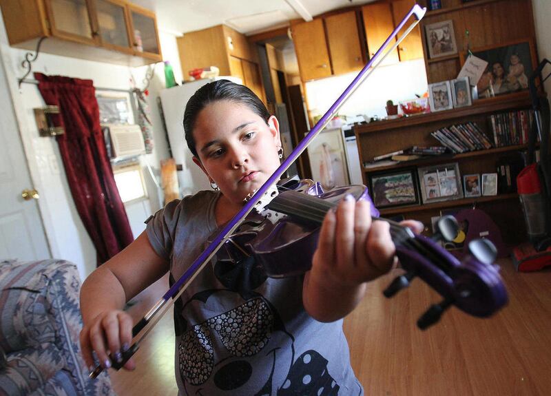 Camille Cruz, 11, plays her purple violin at her home in Farmington, N.M., on Friday, Sept. 7, 2012. Cruz was told that her purple violin was not suitable for the orchestra class and the sixth-grader would have to rent one of the district's violins that i