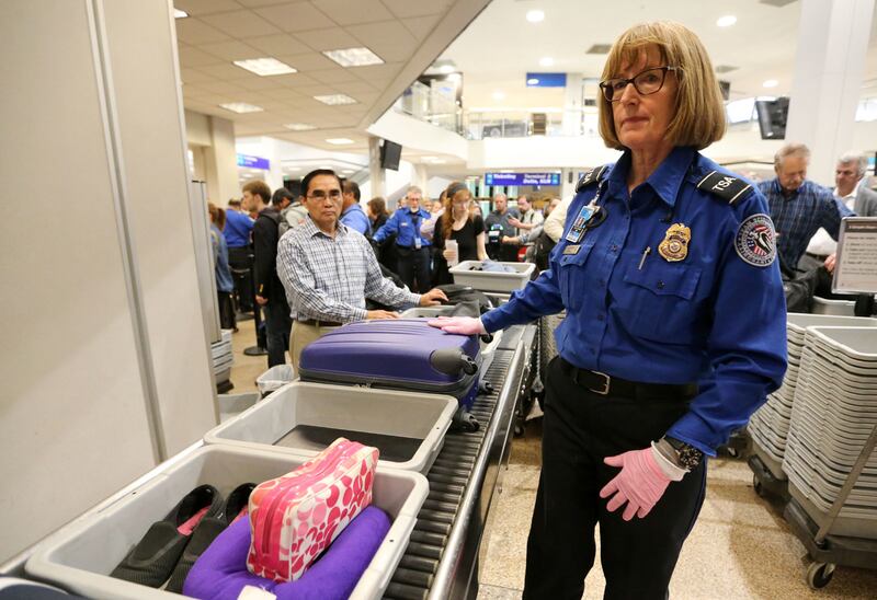 Transportation Security Administration officer Judy Harmer moves items through security screening at the Salt Lake City International Airport in Salt Lake City on Thursday, Oct. 5, 2017.