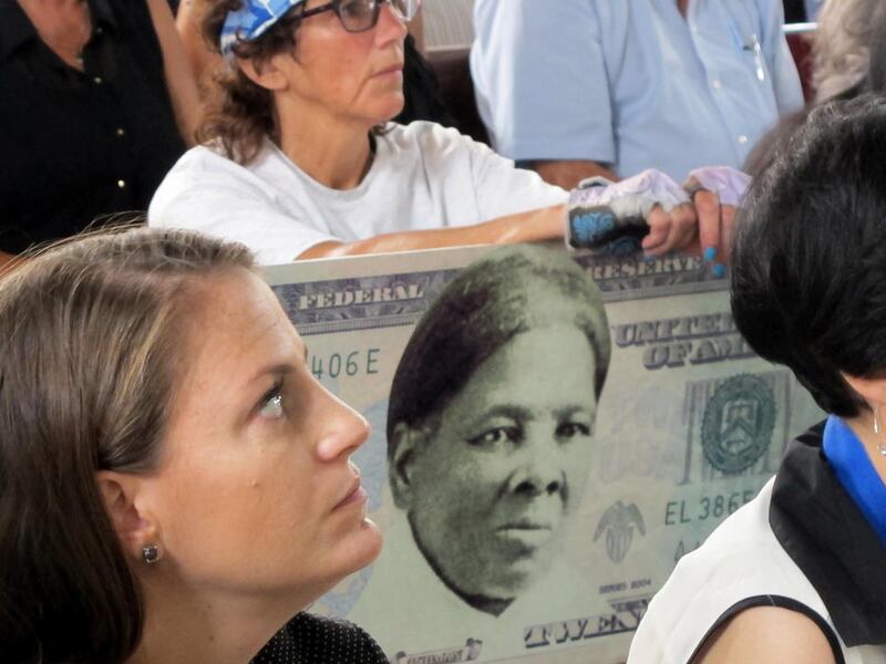 FILE - In this Monday, Aug. 31, 2015, file photo, a woman holds a sign supporting Harriet Tubman for the $20 bill during a town hall meeting at the Women's Rights National Historical Park in Seneca Falls, N.Y. A Treasury official said Wednesday, April 20,