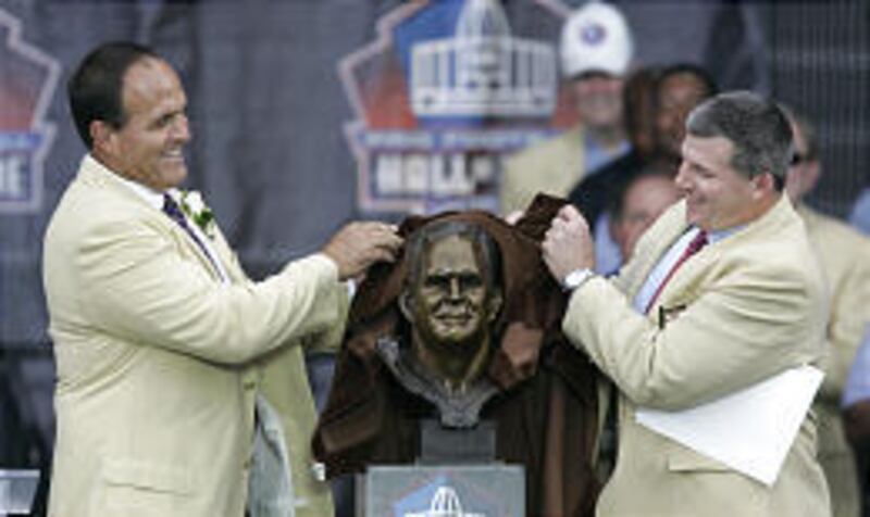 Bruce Matthews, left, and Mike Munchak unveil a bust of Matthews at the Pro Football Hall of Fame.
