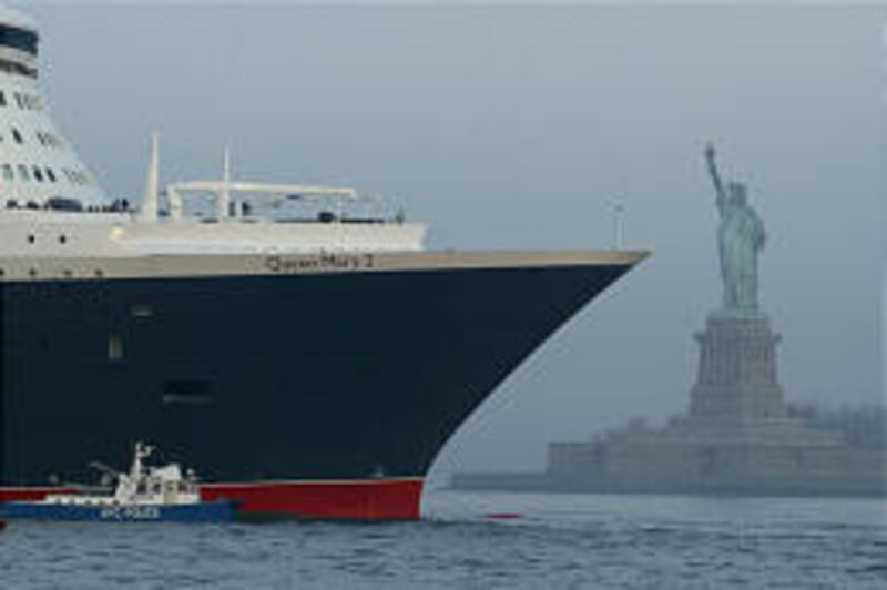 The Queen Mary 2 is escorted by a New York City police boat as it makes its way past the Statue of Liberty on Thursday.
