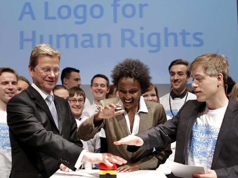 German Foreign Minister Guido Westerwelle, the jury member and Model Waris Dirie from Somalia and the German comedian Michael Mittermaier, from left, press the start button for the humanrightslogo.net website in Berlin, Germany, Tuesday, May 3, 2011. Germ