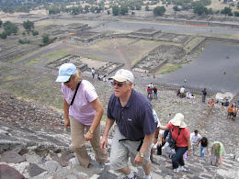 Shelly, left, and Randy Andrus of Gilbert, Ariz., climb a pyramid with other members of a Mormon tour group at the Teotihuacan ruins in Mexico on June 16. A growing number of travelers are paying top dollar for tours and cruises, which connect the ruins t