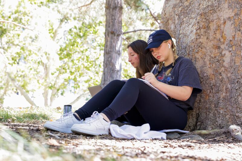 Sophomores Gaelen Kinkead sits next to her friend Ashlay Findley on the University of Utah campus in Salt Lake City.