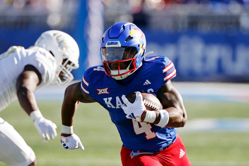 Kansas running back Devin Neal slips past a Central Florida defender on Saturday, Oct. 7, 2023, in Lawrence, Kan.
