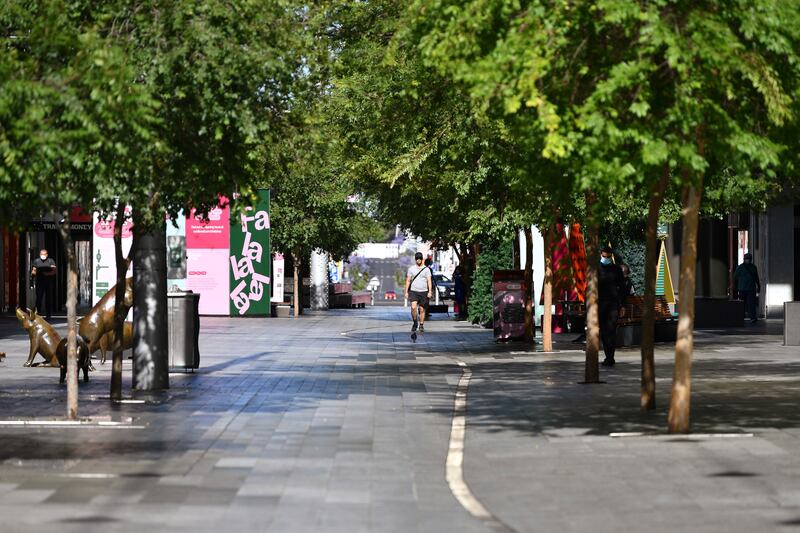 A lone man walks in a nearly empty pedestrian mall in Adelaide, Australia, Thursday, Nov. 19, 2020. South Australia state that includes the city of Adelaide is in a six-day lockdown schools, universities, bars and cafes closed from Thursday and only one person from each household will be allowed to leave home each day, and only for specific reasons.