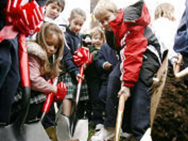 Our Lady of Lourdes students turn over some dirt during groundbreaking Tuesday for Judge Memorial High School project.