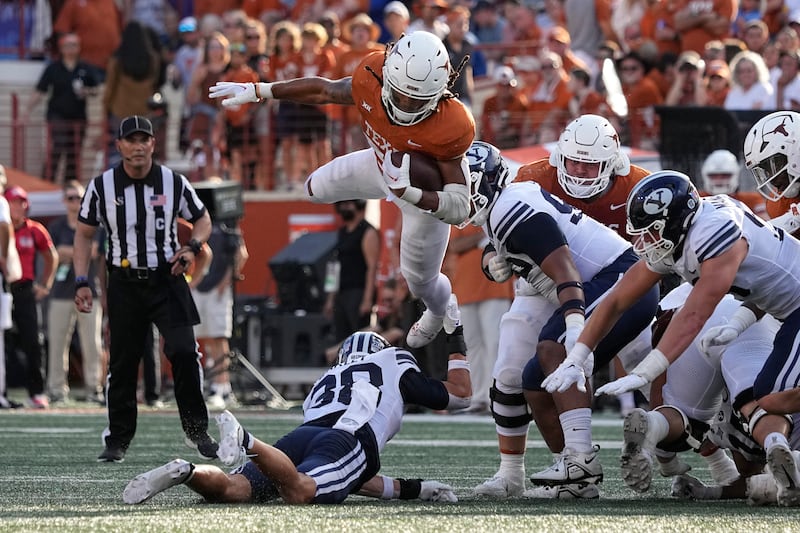 Texas running back Jonathon Brooks (24) is upended by BYU safety Crew Wakley (38) during a Big 12 game on Oct. 28, 2023.