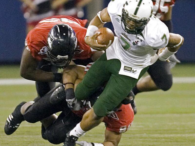 South Florida Bulls quarterback B. J. Daniels is sacked by Northern Illinois' Alan Baxter, bottom, and Brian Lawson during the first half of the International Bowl NCAA college football game in Toronto on Saturday.