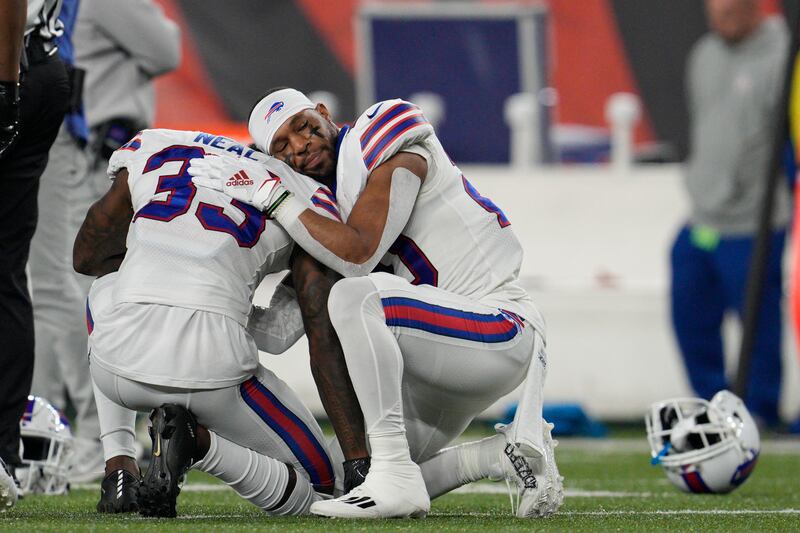 Buffalo Bills’ Siran Neal and Nyheim Hines hug each other after teammate Damar Hamlin was injured Monday, Jan. 2, 2023, in Cincinnati.