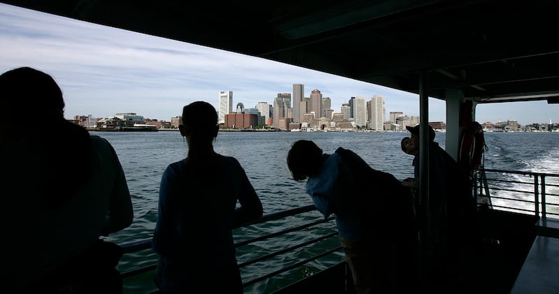 People look at the Boston skyline from a ferry heading to Spectacle Island, a former trash dump now advertised as the jewel of the Boston Harbor Islands, in Boston, Thursday, June 7, 2007. Massachusetts was recently named one of the best places to live af