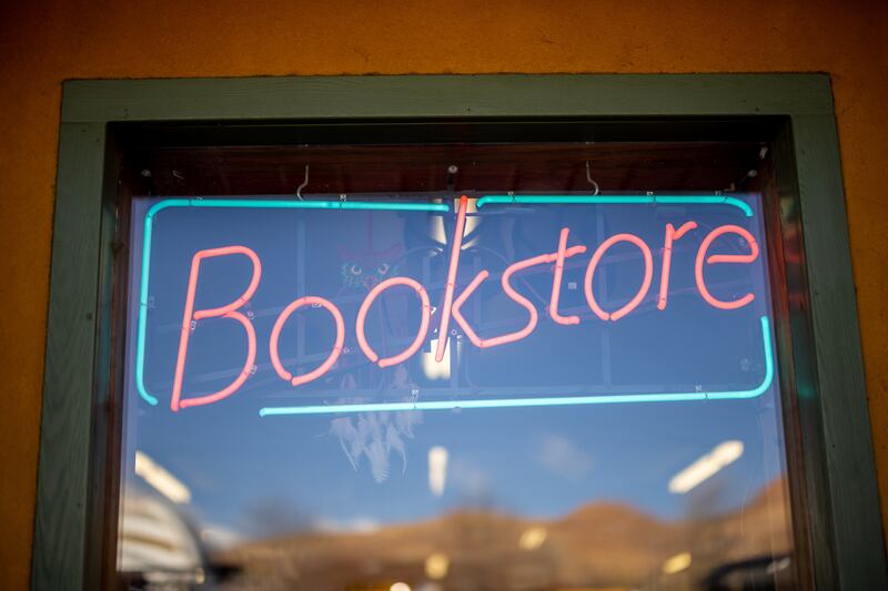 A neon sign is pictured in the window of Back of Beyond Books in Moab on Wednesday, March 30, 2022.