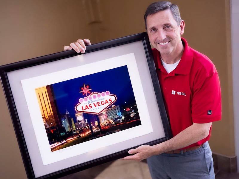 Jeffrey Young, vice president at YESCO, holds a photograph of the “Welcome to Fabulous Las Vegas” sign in Salt Lake City.