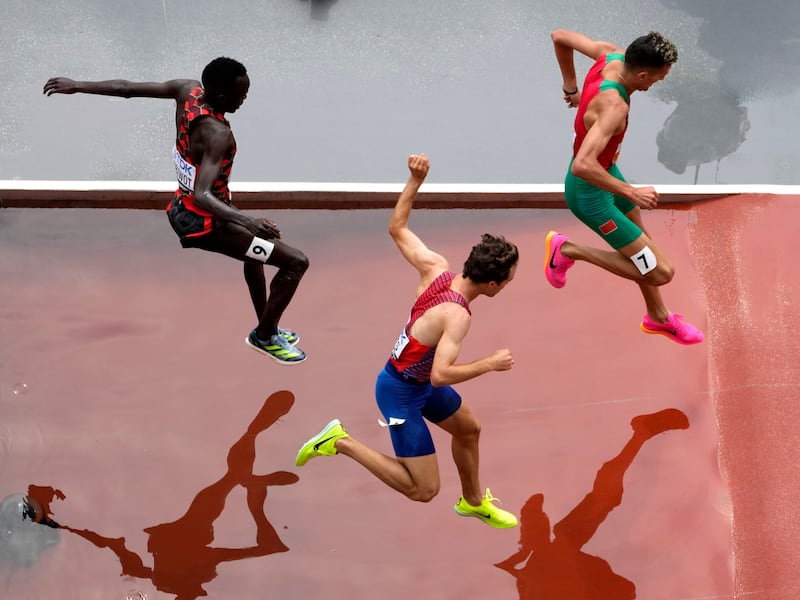 Abraham Kibiwot, Kenneth Rooks, and Soufiane El Bakkali (7), of Morocco, compete in a Men’s 3,000-meter steeplechase heat.