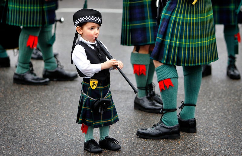 Rowan Miller, 2, stands next to his Grandfather Ian Seivwright as the Shelby County Sheriff's Pipe Band warms up before the start of the annual St Patrick's Day parade Saturday, March 14, 2015 in Memphis, Tenn.