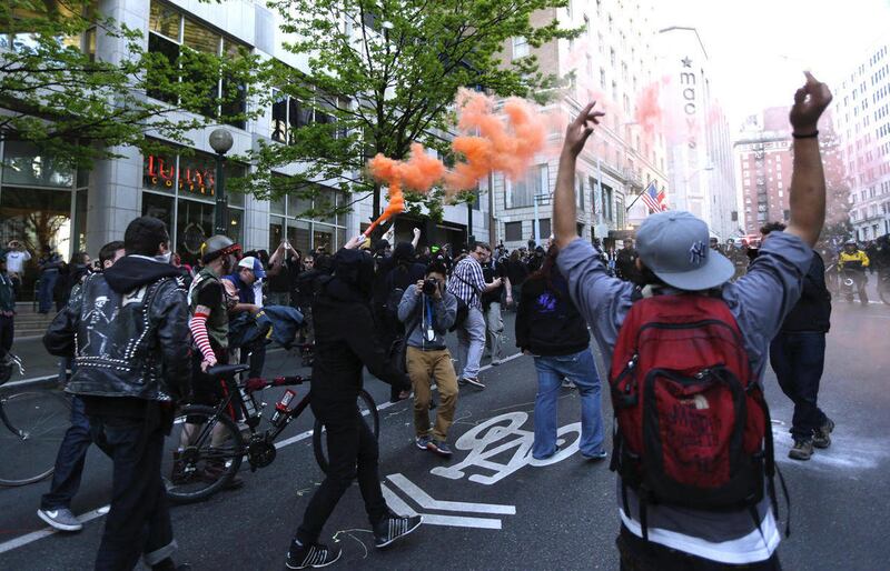 Protesters confront police during a May Day march that began as an anti-capitalism protest and turned into demonstrators clashing with police Wednesday, May 1, 2013, in downtown Seattle.