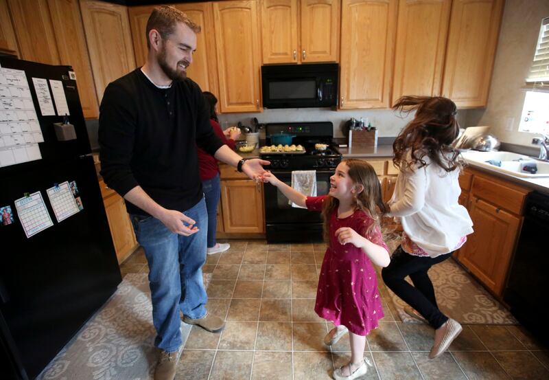 John Smith dances with his daughter Delilah at home in Riverton, Utah, on Monday, April 8, 2019. The Smiths follow Dave Ramsey's cash-only envelope system.