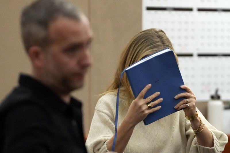 Actor Gwyneth Paltrow shields her face with a blue notebook as she exits a courtroom, Tuesday, in Park City, where she is accused in a lawsuit of crashing into a skier during a 2016 family ski vacation, leaving him with brain damage and four broken ribs.