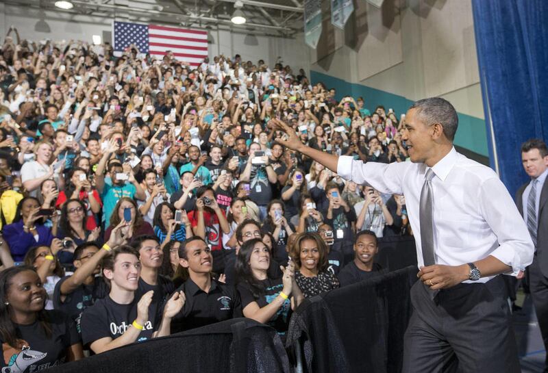 President Barack Obama waves as he is introduced before speaking in the gym at Coral Reef High School, Friday, March 7, 2014 in Miami.
