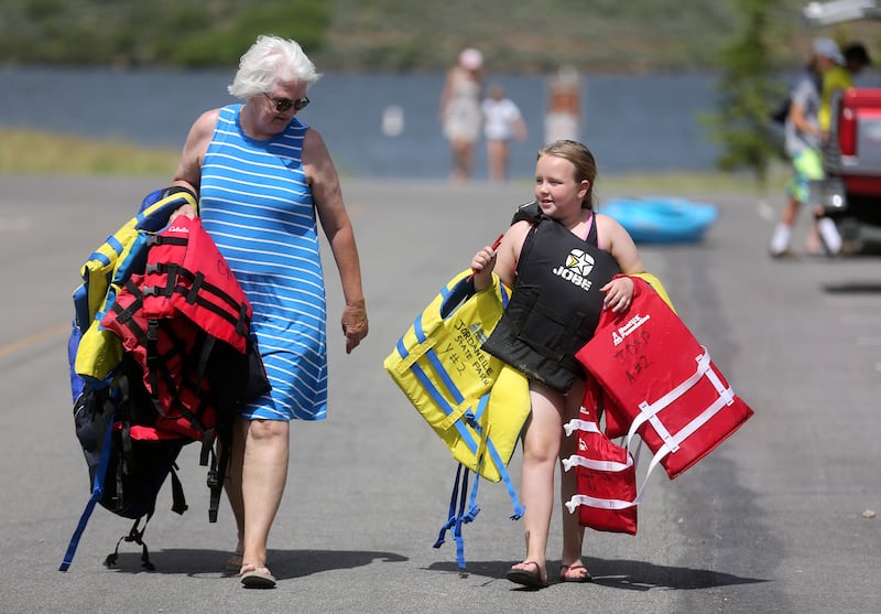 Carla Sharp and Zoey Sharp carry life jackets to return to the life jacket loaner station after using them at Jordanelle State Park on Wednesday, June 26, 2019.