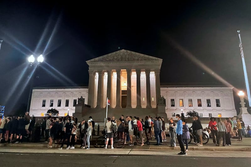 A crowd of people gather outside the Supreme Court.