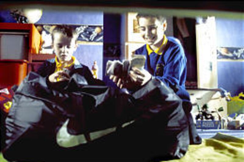Damian (Alex Etel), left, and his brother Anthony (Lewis McGibbon) open up a bag of money in "Millions."