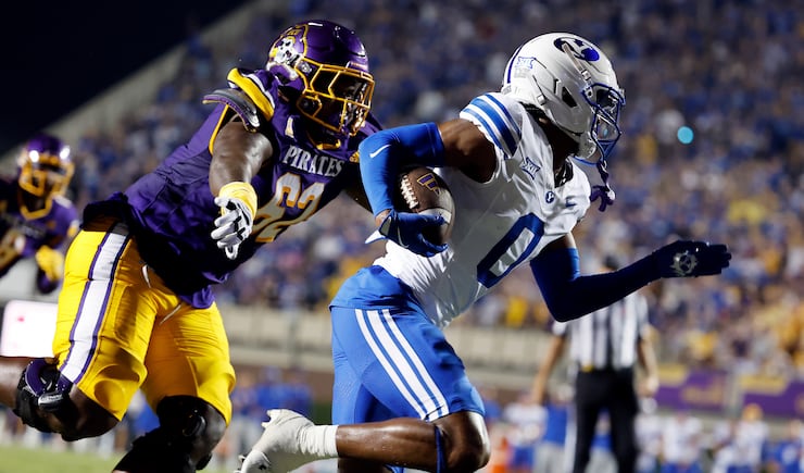 BYU's Evan Johnson (0) runs away from East Carolina offensive lineman Jimarion McCrimon (62) after his interception during game in Greenville, N.C., Saturday, Sept. 20, 2025.