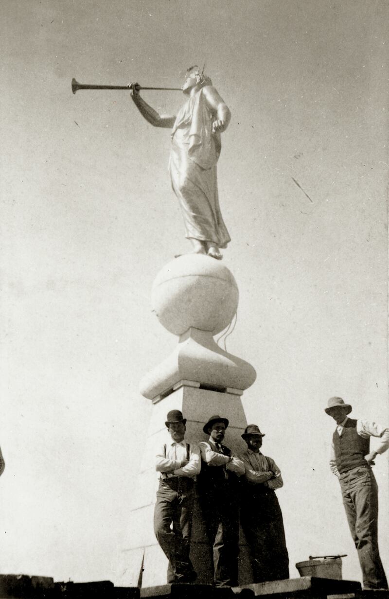 Workers stand atop the Salt Lake Temple after laying the capstone and placing the Angel Moroni statue atop it in April 1892.