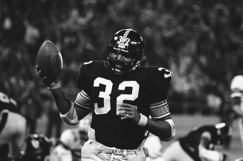 Franco Harris holds the ball in the air after scoring against the Dallas Cowboys Sunday, Nov. 21, 1977.