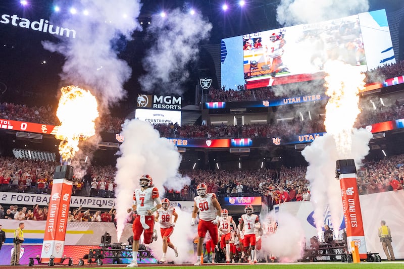 The Utah Utes storm the field before playing against the USC Trojans in the Pac-12 championship at the Allegiant Stadium.