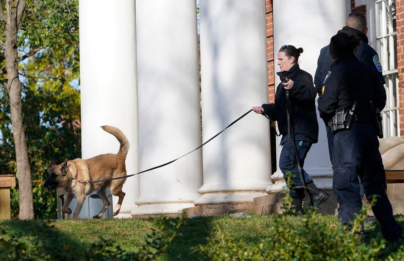 A Virginia Department of Corrections canine team searches the scene near a shooting that occurred Nov. 14 in Charlottesville. Va.