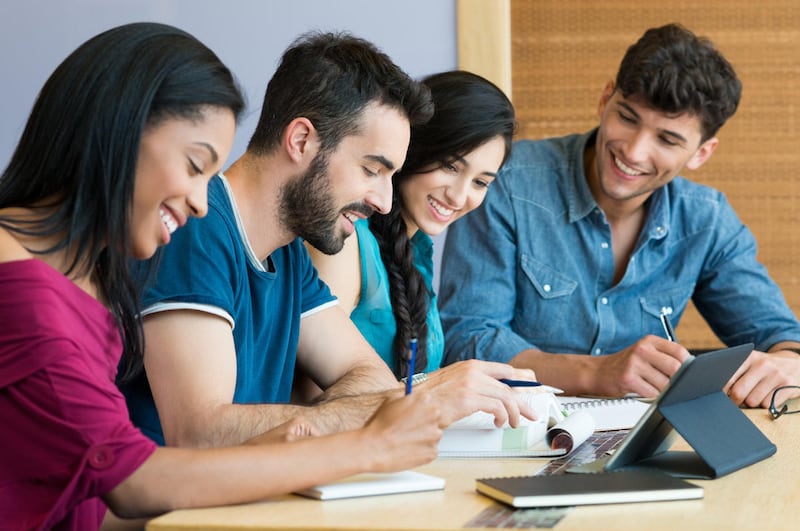 Closeup shot of young man and woman discussing on note. Happy smiling students preparing the exam. Team of students studying together for the university exam.