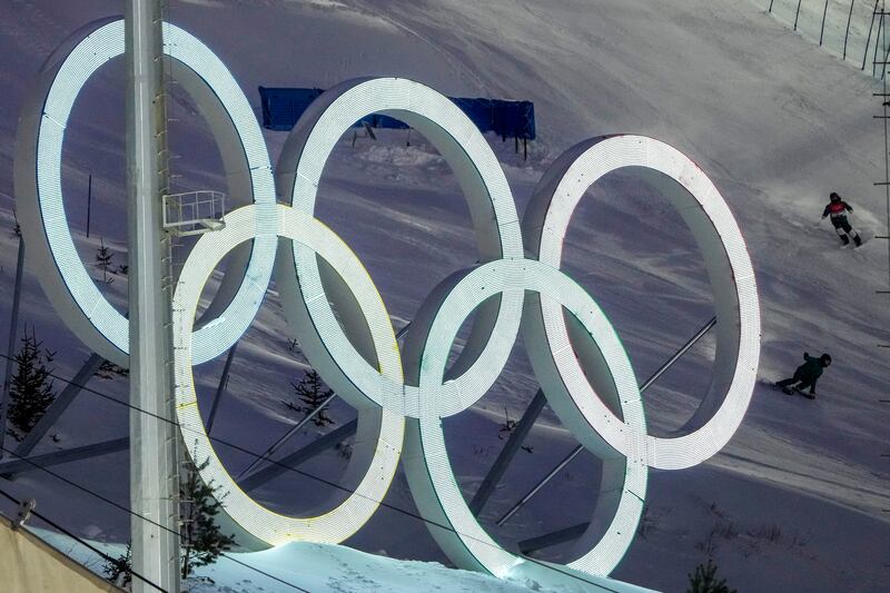 Freestyle skiers speed down by the Olympic Rings ahead of the 2022 Winter Olympics in Zhangjiakou, China.