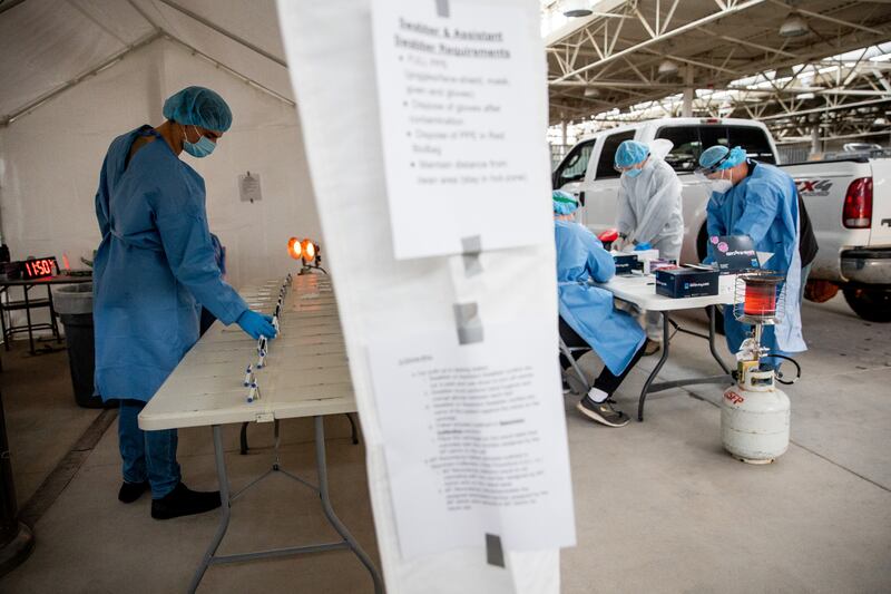 Utah National Guard Pfc. Noah Filoso keeps track of timers on COVID-19 rapid tests at the Fairpark in Salt Lake City.