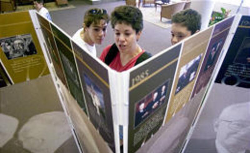 Jennifer Reed, left, and Virginia Piazza and son Christopher eye photos.