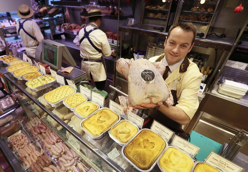 Danny Lidgate displays a turkey at his butchers shop in Holland Park in London, Tuesday, Nov. 25, 2014. Butcher Danny Lidgate, whose 160-year-old shop C. Lidgate, butcher and charcuterie, has been in the same family for five generations, says Americans ju